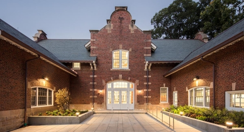 The east facade and entryway with planting on either side as well as a ramp for ADA accessibility.