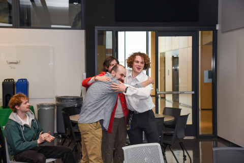 people group hugging in response to winning a competition