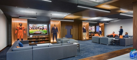 A room with couches surrounding several TVs for relaxing and socializing.