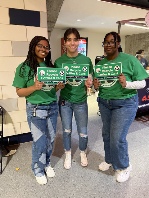 Volunteers holding "Please Recycle!" signs.